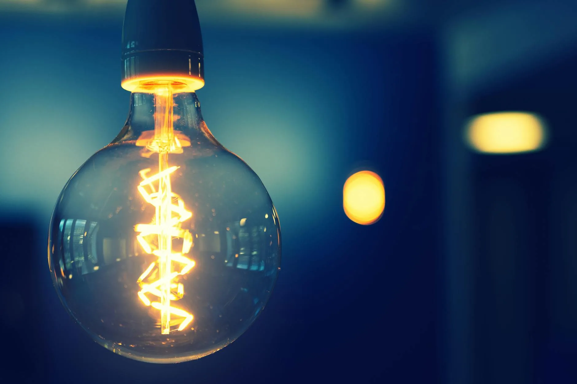 Warm glowing lightbulb against a dark background