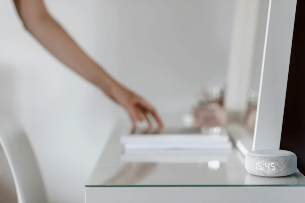 Smart speaker on bedside table in a bright morning bedroom